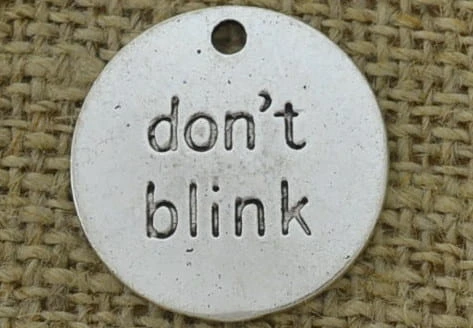 Zawieszka mała moneta "don't blink" kolor srebrny