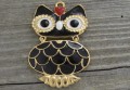 20824 Zawieszka duża sówka emaliowana czarna z wykończeniem w kolorze złotym